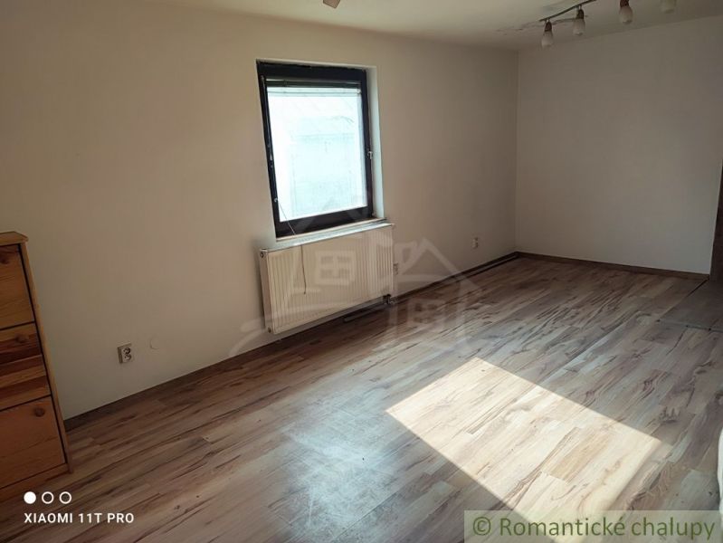 Ein Zimmer mit einem Holzboden und einfacher Einrichtung in einem Einfamilienhaus.