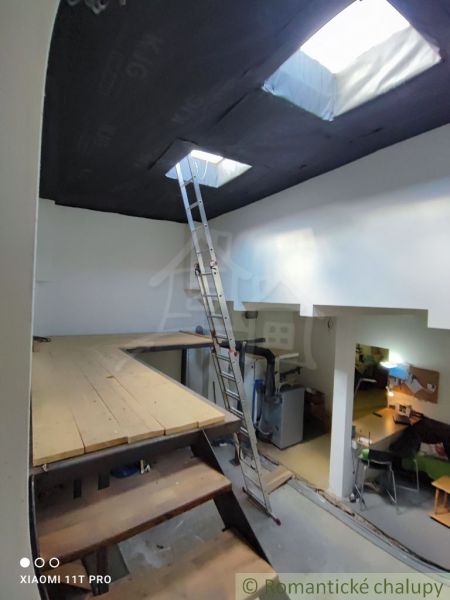 Dachboden mit Leiter und Boden in Holzoptik in einem Einfamilienhaus.