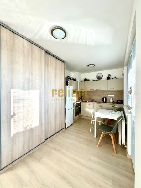 Küchenecke mit Holzboden und Einbauschrank in einer Einzimmerwohnung.