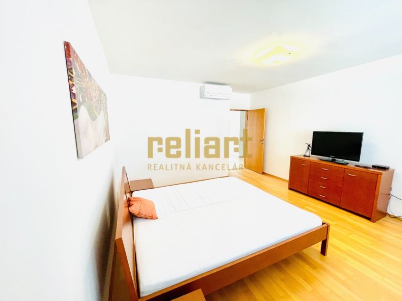 Helles Schlafzimmer in einer 4-Zimmer-Wohnung mit Holzboden, Bett und Kommode.