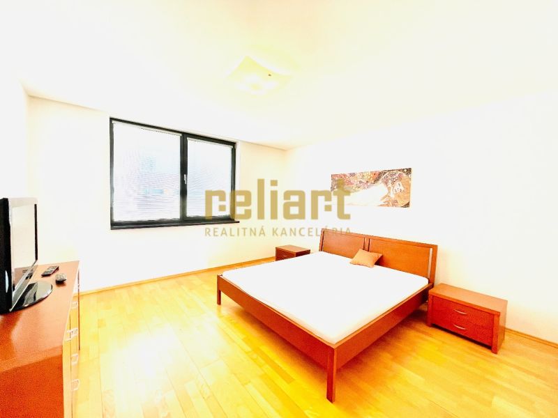 Helles Schlafzimmer mit stilvollen Möbeln und Holzboden in einer 4-Zimmer-Wohnung.