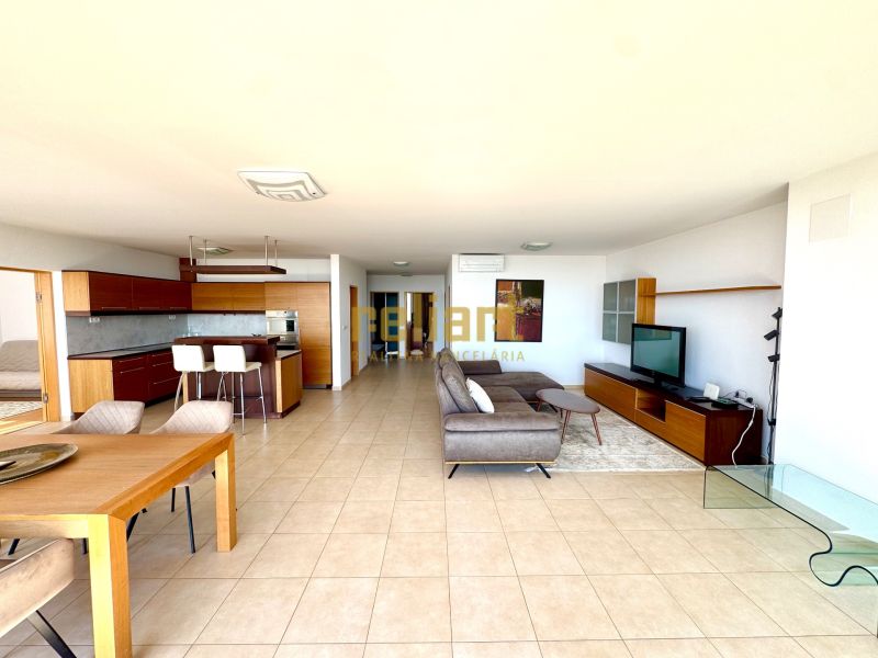 Geräumiges Wohnzimmer in einer 4-Zimmer-Wohnung mit Küche, Fliesen und bequemer Sitzgelegenheit.