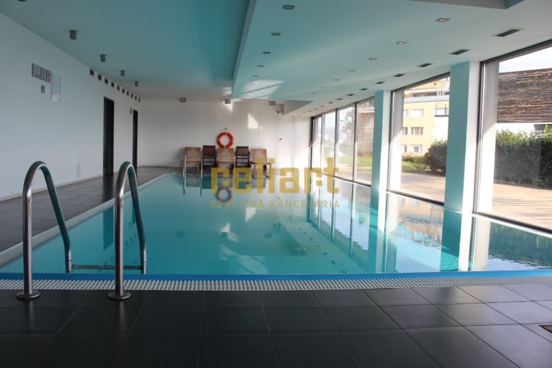 Innenpool mit Liegestühlen in einer 4-Zimmer-Wohnung.