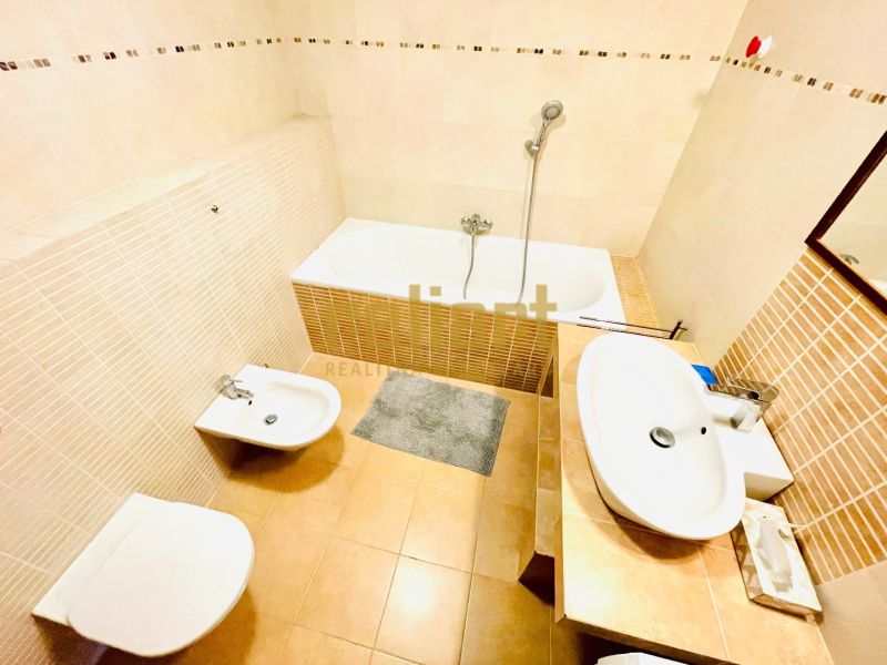 Badezimmer in einer 4-Zimmer-Wohnung mit Badewanne, Bidet und Waschbecken in hellen Farbtönen.