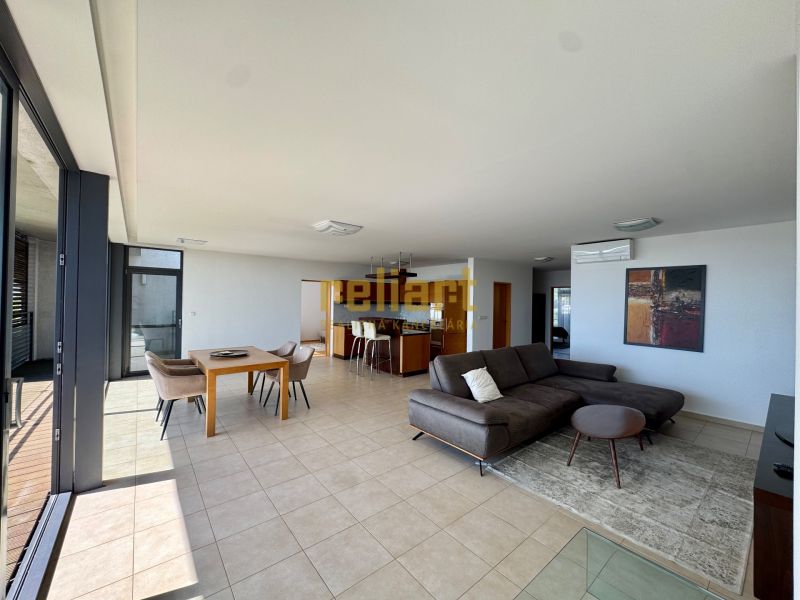 Geräumiges Wohnzimmer in einer 4-Zimmer-Wohnung mit großen Fenstern, Sofa und Esstisch.