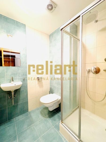 Badezimmer mit Toilette, Dusche und Waschbecken in einer 4-Zimmer-Wohnung.