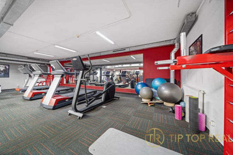 Fitnesscenter mit Laufbändern und Trainingsgeräten in Geschäftsräumen.