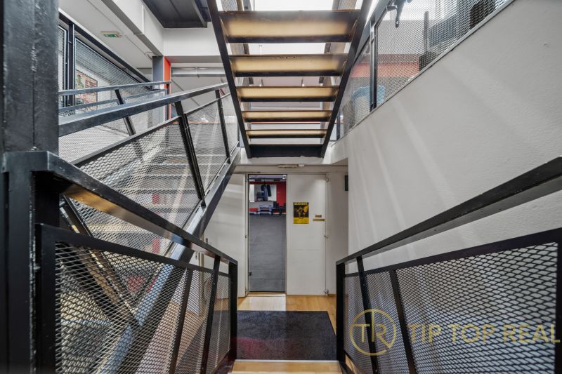Ein Flur mit einer Metalltreppe und einem Gittergeländer in Geschäftsräumen.