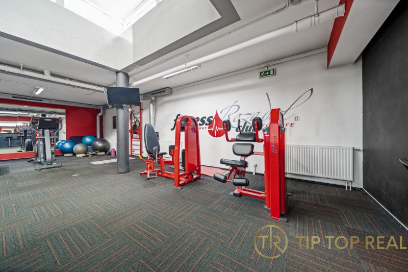 Fitnesscenter mit Kraftgeräten, Laufband und Gymnastikbällen, Geschäftsräume.