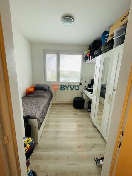 Kleines Zimmer in einer 3-Zimmer-Wohnung mit Bett und Schrank, Boden mit Holzdekor.