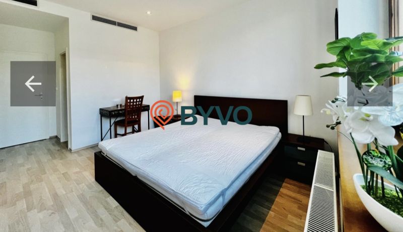 Schlafzimmer mit großem Bett, Schreibtisch und Holzboden in einer 3-Zimmer-Wohnung.