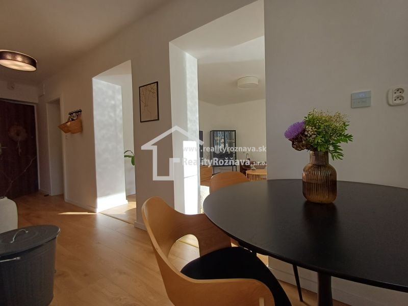 Innenraum einer 2-Zimmer-Wohnung mit Holzboden und einer Vase auf dem Tisch.