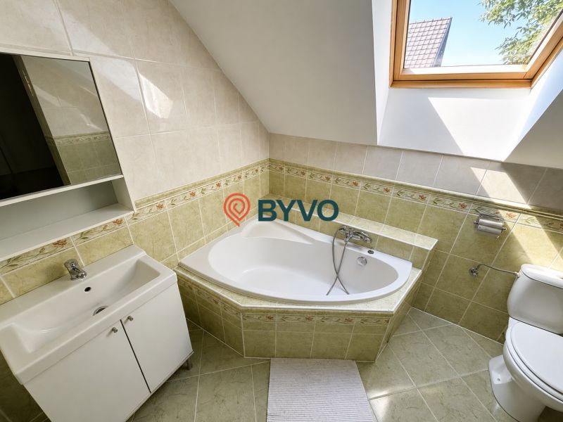 Badezimmer in einem Einfamilienhaus mit Dachfenster und Eckbadewanne.