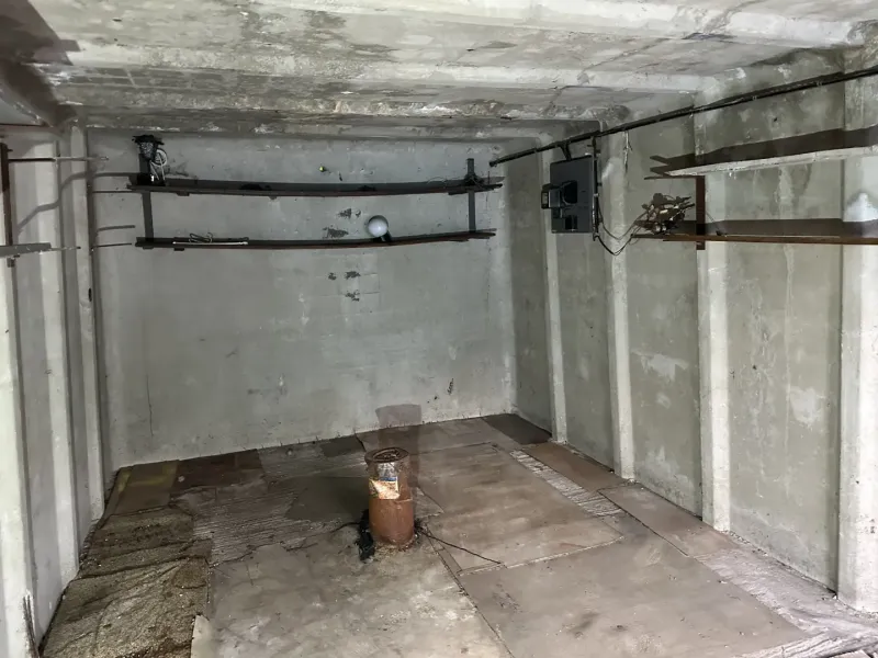 Ein Betonraum mit Halterungen an der Wand und einem Boden mit Holzdekor in Garagen.