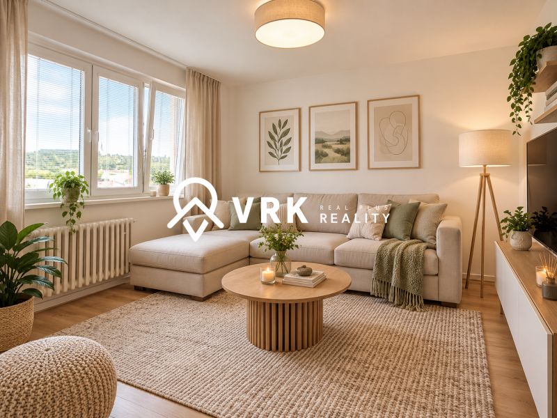Wohnzimmer in einer Zweizimmerwohnung mit Sofa, Pflanzen und Holzboden.