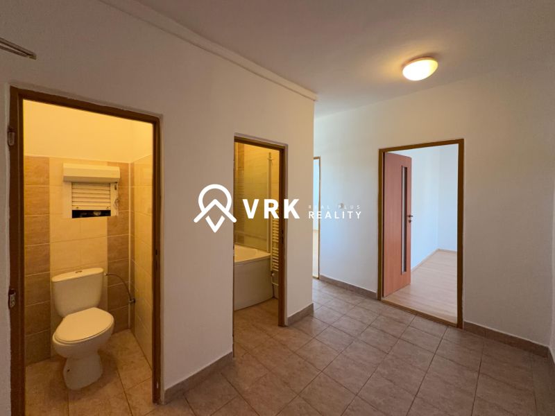 Flur in einer 2-Zimmer-Wohnung mit Fliesen und Holzboden-Dekor im Zimmer.