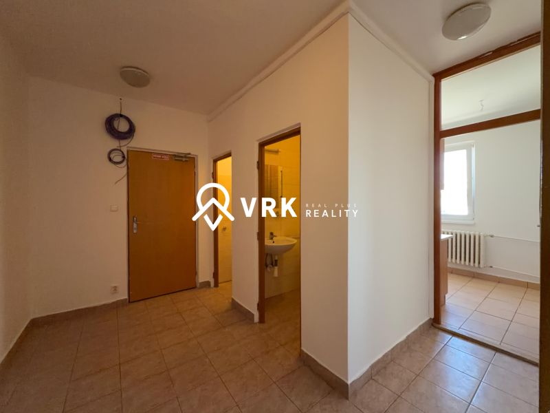 Innenraum einer 2-Zimmer-Wohnung mit Fliesen, links das Badezimmer und rechts ein Raum mit Fenster.