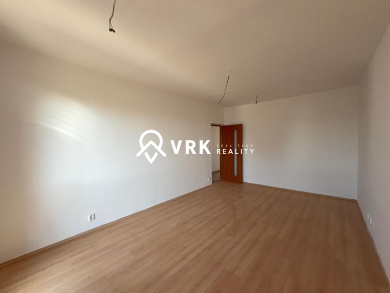 Ein Zimmer mit Wänden in einer 2-Zimmer-Wohnung und einem Boden mit Holzdekor.