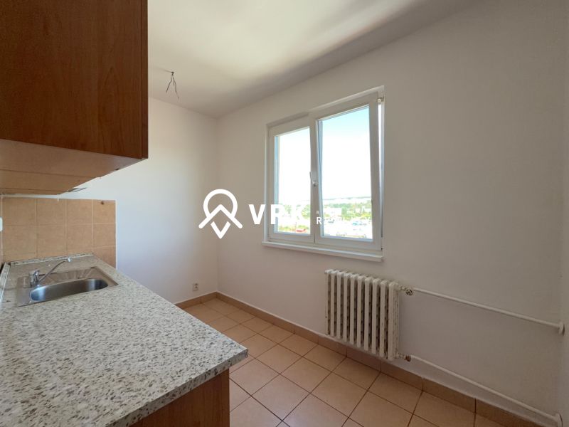 Küche in einer 2-Zimmer-Wohnung mit Keramikboden, einfachen Schränken und einem Fenster mit Aussicht.