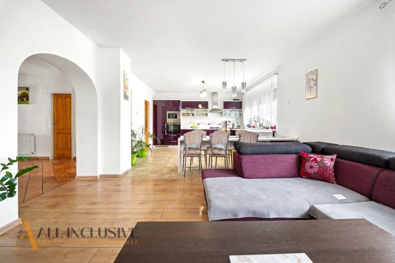 Innenraum eines Einfamilienhauses mit Küche, Esstisch und Boden mit Holzdekor.
