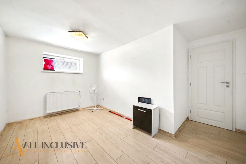 Weißer Raum mit Holzboden in einem Einfamilienhaus.