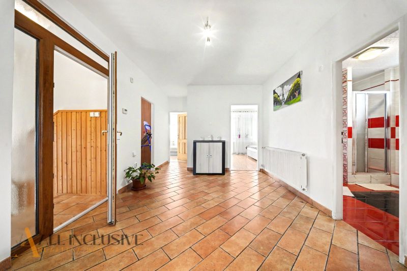 Ein geräumiger Flur mit Fliesenboden in einem Einfamilienhaus, mit Holzelementen im Innenraum.