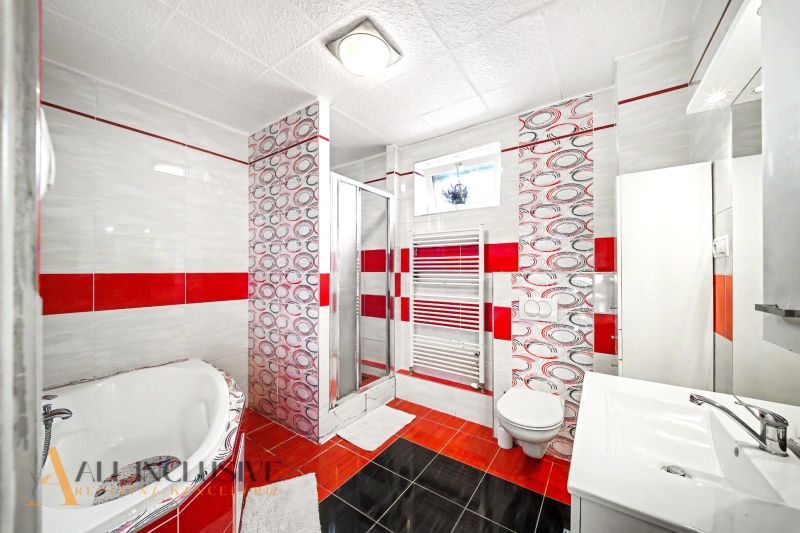 Badezimmer im Einfamilienhaus mit Badewanne, Toilette und Duschkabine.