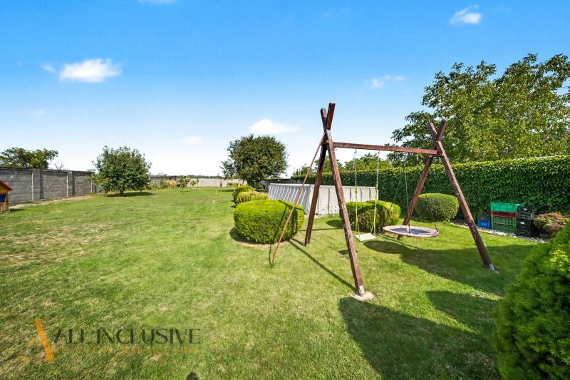 Der Garten des Einfamilienhauses in Vojtechovce in Nový Život mit einer Schaukel und einem Pool.