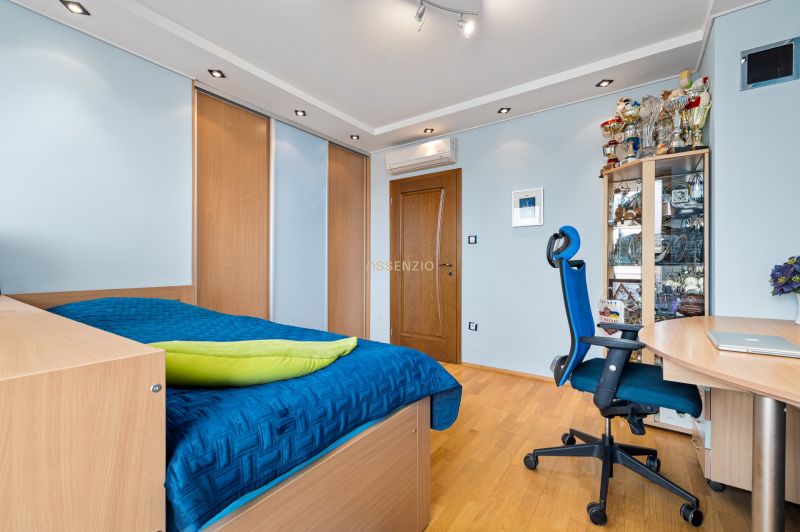 Schlafzimmer in einem Einfamilienhaus mit Schrank, blauem Bett, Trophäen und Holzboden.