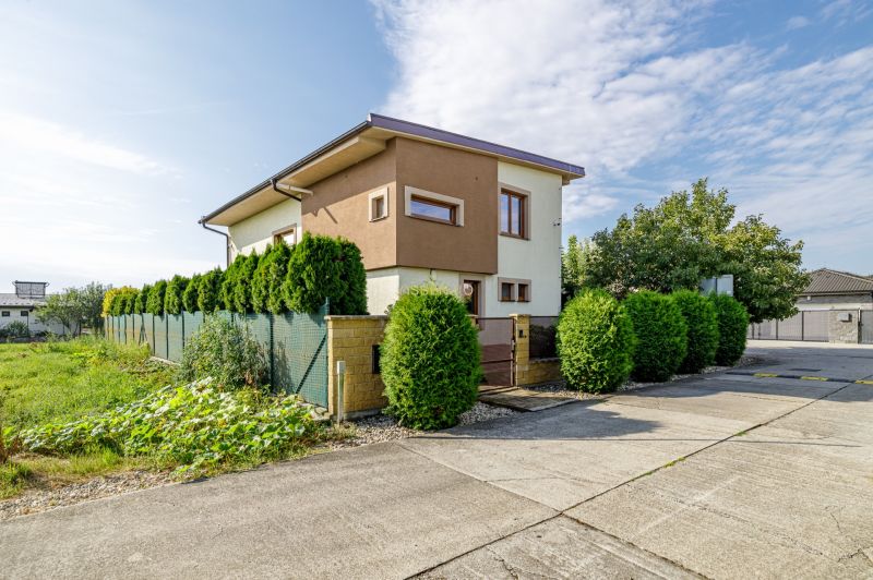 Ein Einfamilienhaus in der Majerská-Straße in Nová Dedinka mit einem gepflegten Garten und grünen Sträuchern.