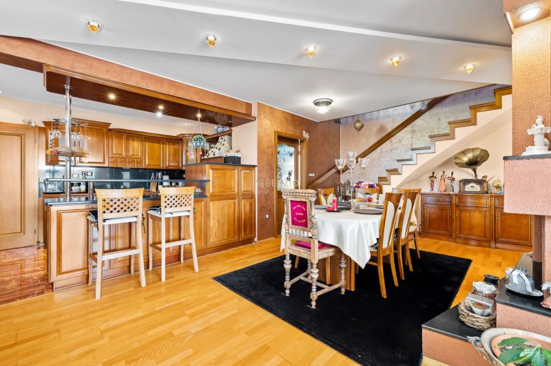 Innenraum eines Einfamilienhauses mit Küche, Esstisch und Boden mit Holzdekor.