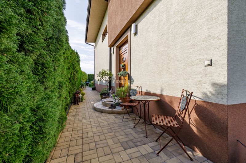 Ein Einfamilienhaus in der Majerská-Straße in Nová Dedinka mit einem Außenbereich zum Sitzen und einer Hecke.
