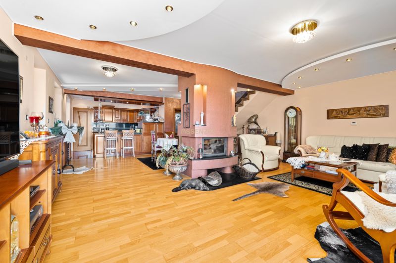 Wohnzimmer in einem Einfamilienhaus mit Kamin und Boden in Holzoptik.