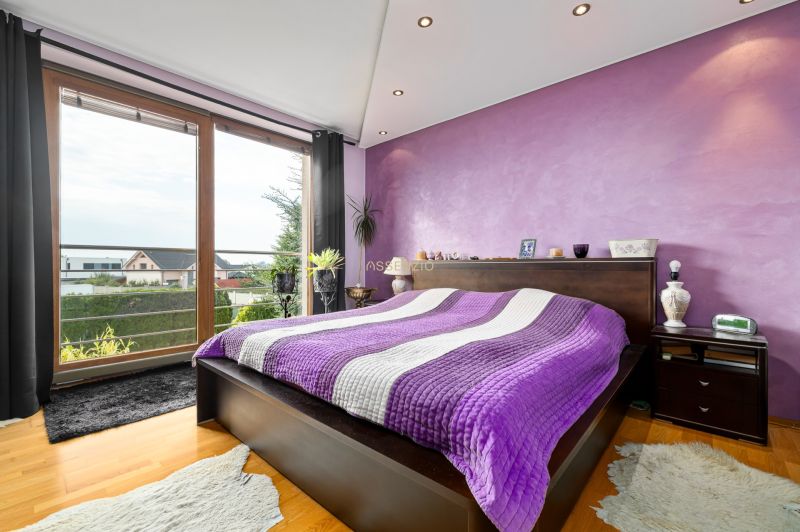 Stilvolles Schlafzimmer mit lila Wand und Aussicht, Boden mit Holzdekor.
