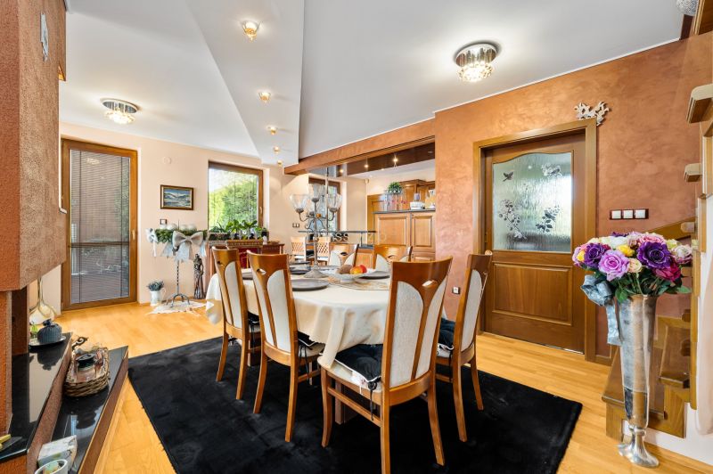 Esszimmer in einem Einfamilienhaus mit Holzboden und dekorativen Blumen.