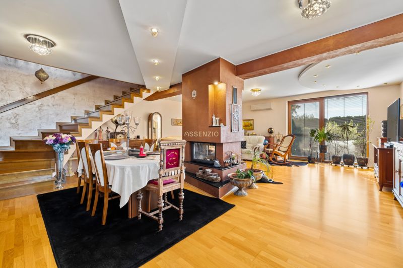 Einfamilienhaus mit Esstisch, Kamin, Holztreppe und Boden mit Holzdekor.