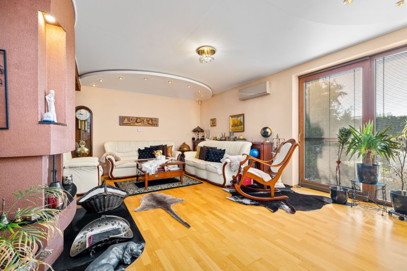 Wohnzimmer in einem Einfamilienhaus mit Kamin und Boden in Holzoptik.