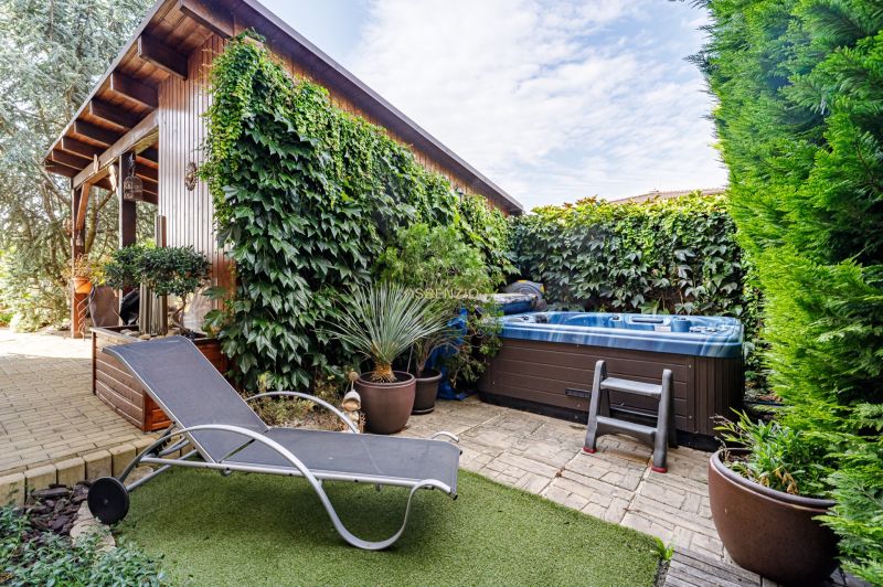 Der Garten des Einfamilienhauses mit Liegestuhl, Whirlpool und Kletterpflanzen in der Majerská in Nová Dedinka.