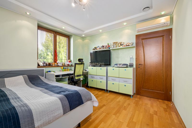 Kinderzimmer mit Bett, Schreibtisch und Holzboden in einem Einfamilienhaus.