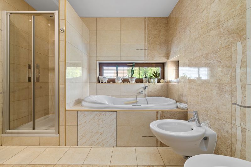 Badezimmer im Einfamilienhaus mit Badewanne, Dusche und Bidet.