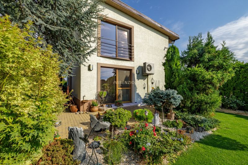 Ein Einfamilienhaus in der Majerská-Straße in Nová Dedinka mit einem bunten Garten und einer Terrasse.
