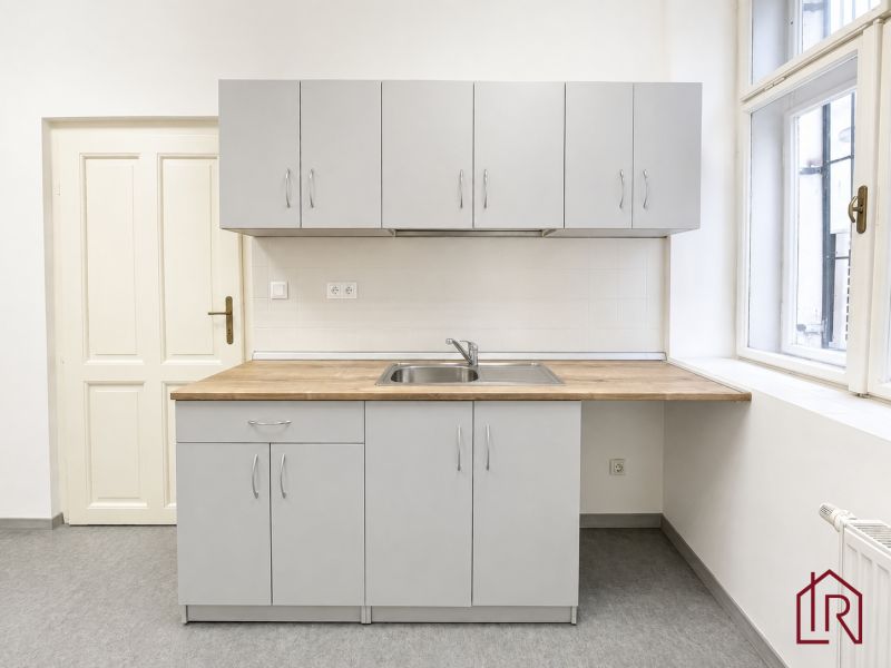Graue Küchenzeile mit Holzarbeitsplatte im Büro.