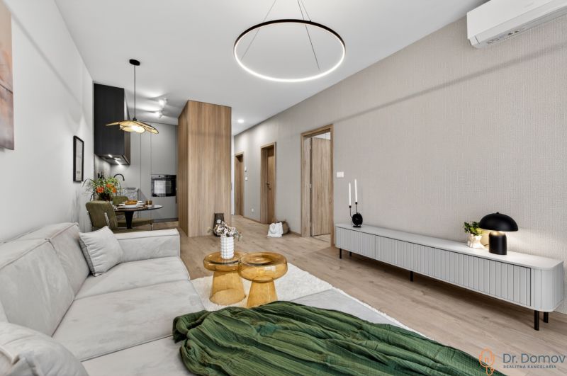 Wohnzimmer in einer 2-Zimmer-Wohnung mit Holzboden und bequemer Sitzgelegenheit.