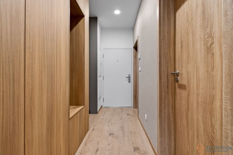 Flur in einer 2-Zimmer-Wohnung mit Holzboden und Holztüren.