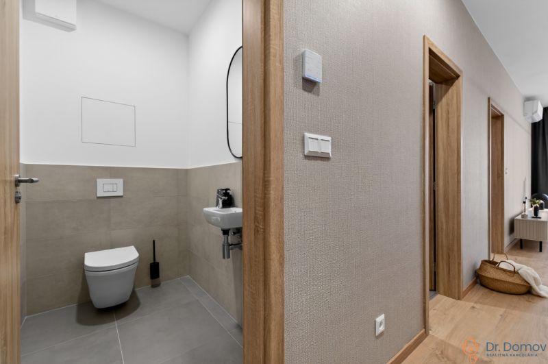 Flur und Toilette in einer 2-Zimmer-Wohnung mit Holzboden.