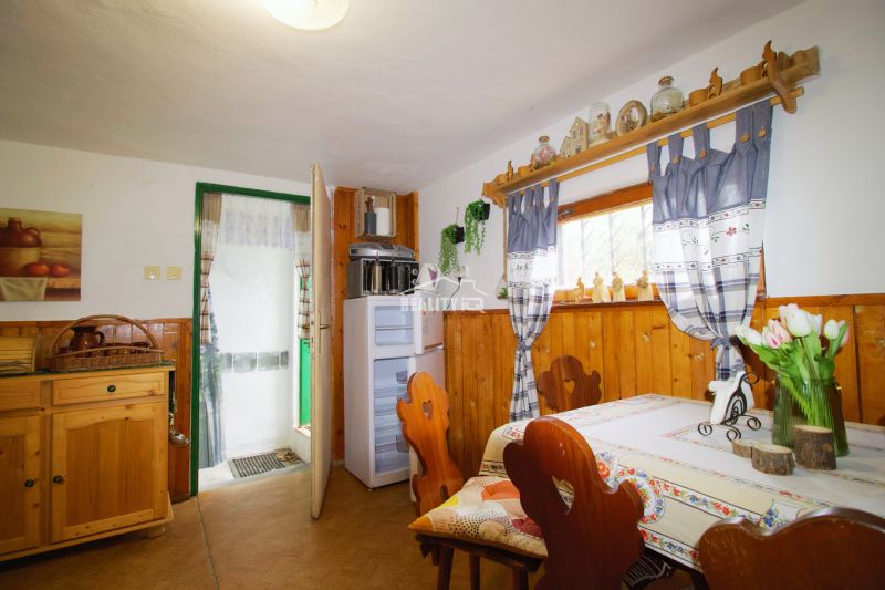 Das Innere der Hütte mit Holzelementen, traditionellem Mobiliar und einem dekorierten Fenster.