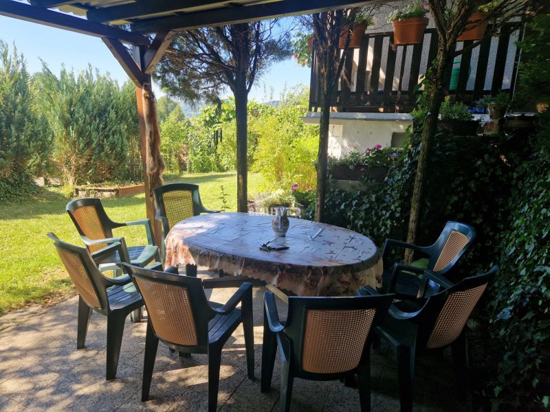 Garten mit Terrasse bei der Hütte in Žilina, Plastikstühle um den Tisch.