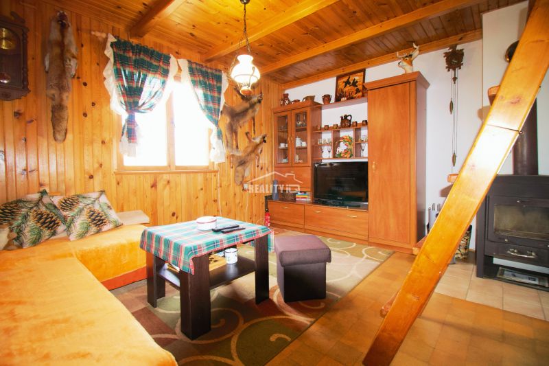 Interieur einer Hütte mit Holzeinrichtung und traditionellem Mobiliar für einen gemütlichen Aufenthalt.