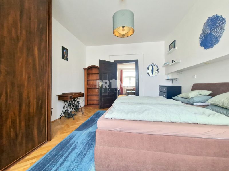 Schlafzimmer in einer 3-Zimmer-Wohnung mit Holzboden, Doppelbett und Möbeln.