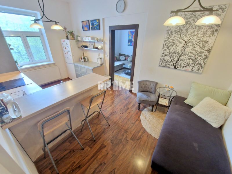 Küche in einer 3-Zimmer-Wohnung mit Bartresen und Holzboden.